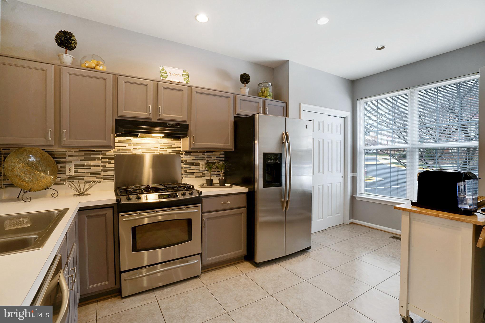 11459 Heritage Commons Way Reston, VA 20194 - Photo 9 of 30 a kitchen with stainless steel appliances granite countertop a stove a refrigerator and a microwave