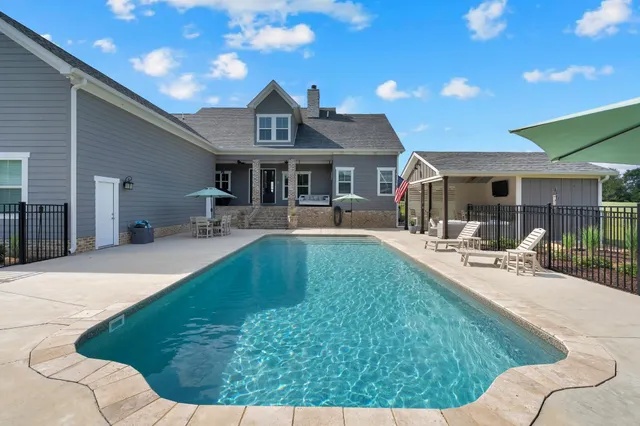 a bathroom with a granite countertop sink a mirror and shower curtain