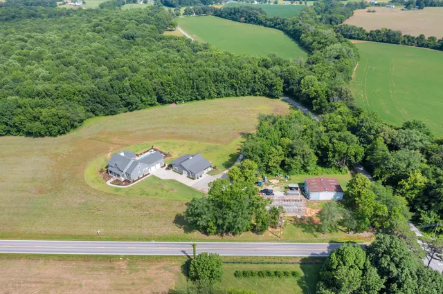 a view of backyard of house and car parked