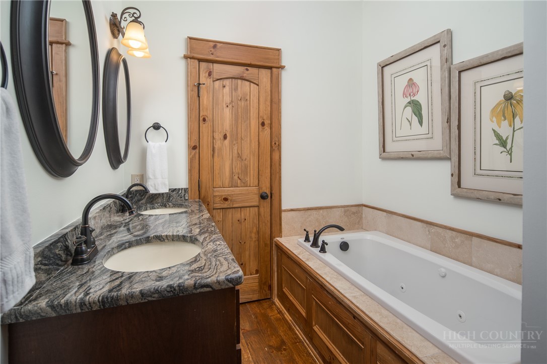 153 Stonecrop Lane Boone, NC 28607 - Photo 29 of 50 a bathroom with a granite countertop tub sink and mirror