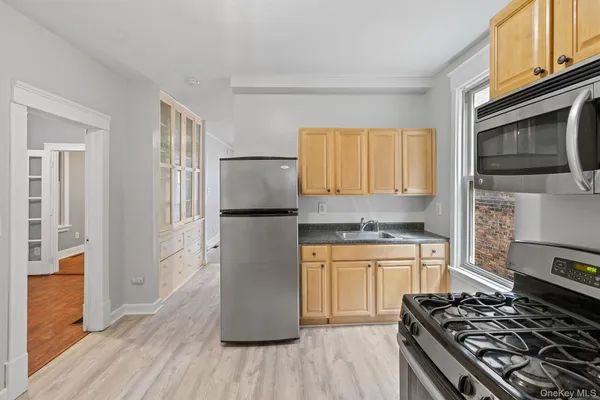 a kitchen with stainless steel appliances granite countertop a stove top oven a refrigerator and a microwave