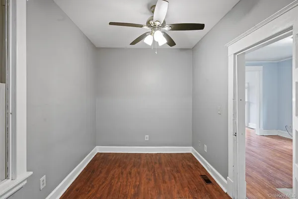 a view of a room with wooden floor and a ceiling fan