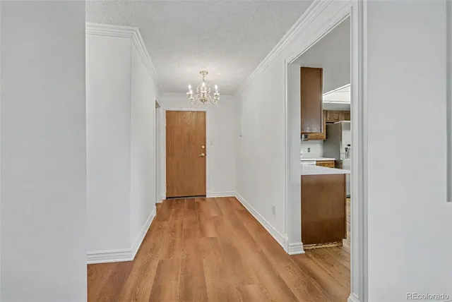 a view of a hallway with wooden floor and a bathroom