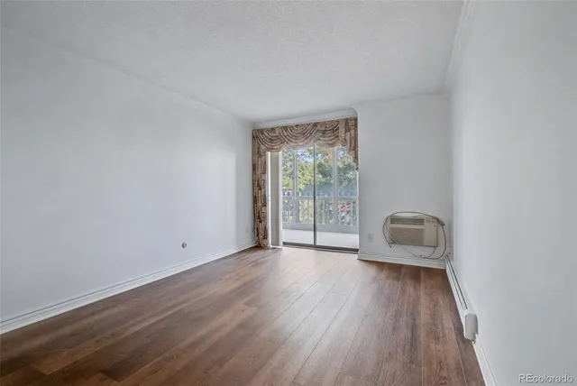 a view of an empty room with wooden and a window