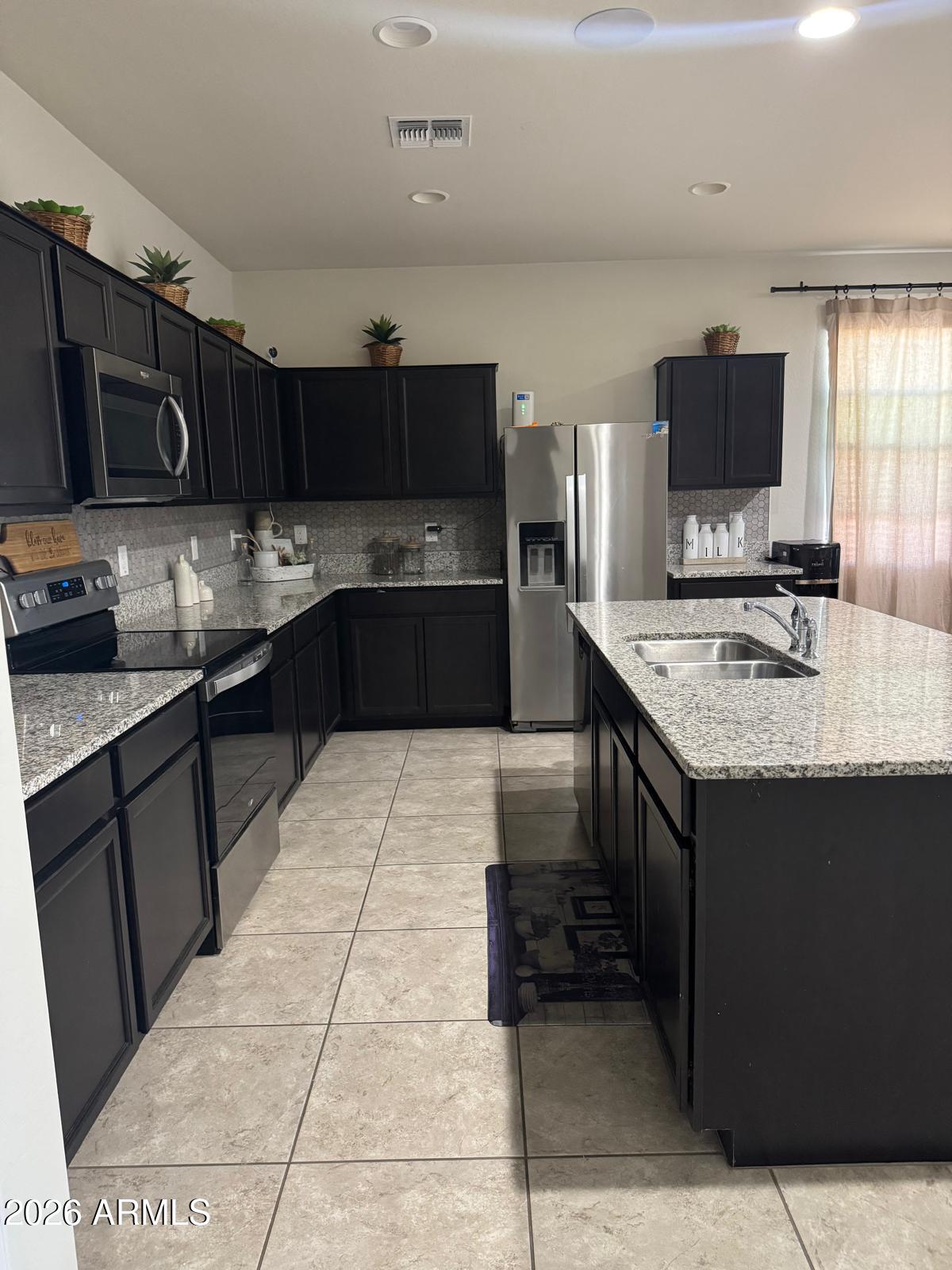 7851 West Riverside Avenue Phoenix, AZ 85043 - Photo 15 of 40 a kitchen with a sink and a stove top oven with wooden cabinets