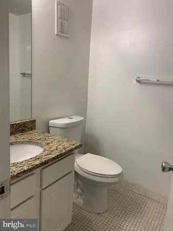 a bathroom with a granite countertop toilet and a sink
