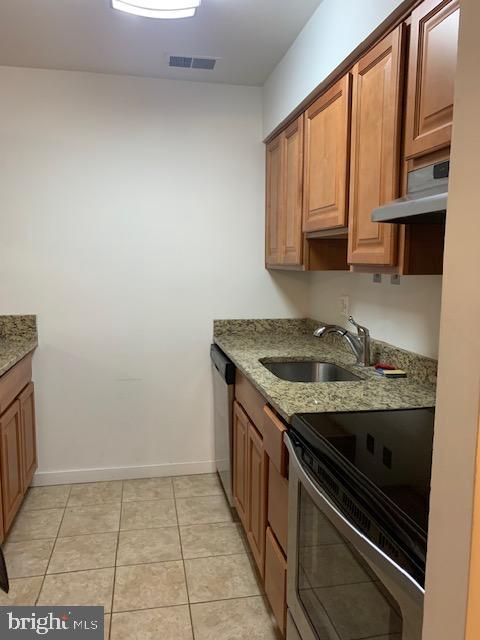 626 South Charles Street, Unit R 25 Baltimore, MD 21230 - Photo 7 of 17 a kitchen with granite countertop a sink stove and cabinets