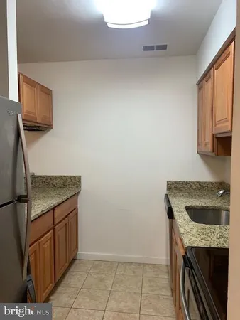 a kitchen with granite countertop a sink and a stove