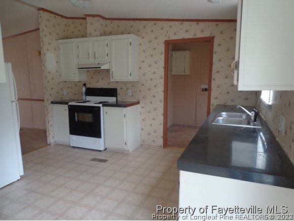 705 Winding Ridge Sanford, NC 27332 - Photo 5 of 10 a kitchen with stainless steel appliances granite countertop a sink stove and refrigerator