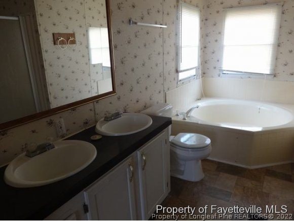 705 Winding Ridge Sanford, NC 27332 - Photo 8 of 10 a bathroom with a sink toilet and a mirror