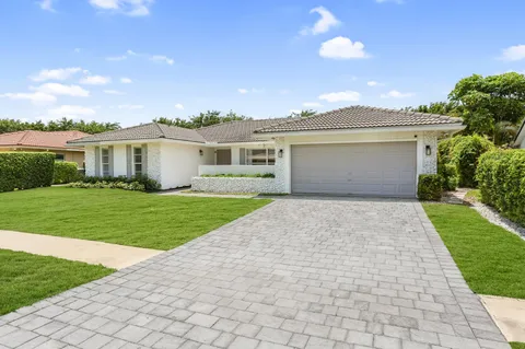 a front view of a house with a garden and yard