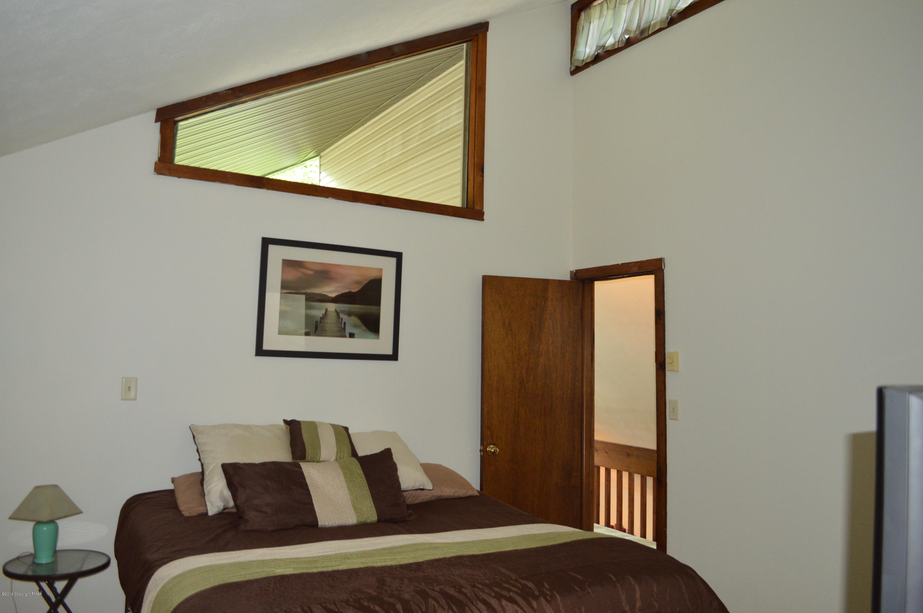 256 Fern Ridge Road Blakeslee, PA 18610 - Photo 13 of 27 a bedroom with a bed and wall painting