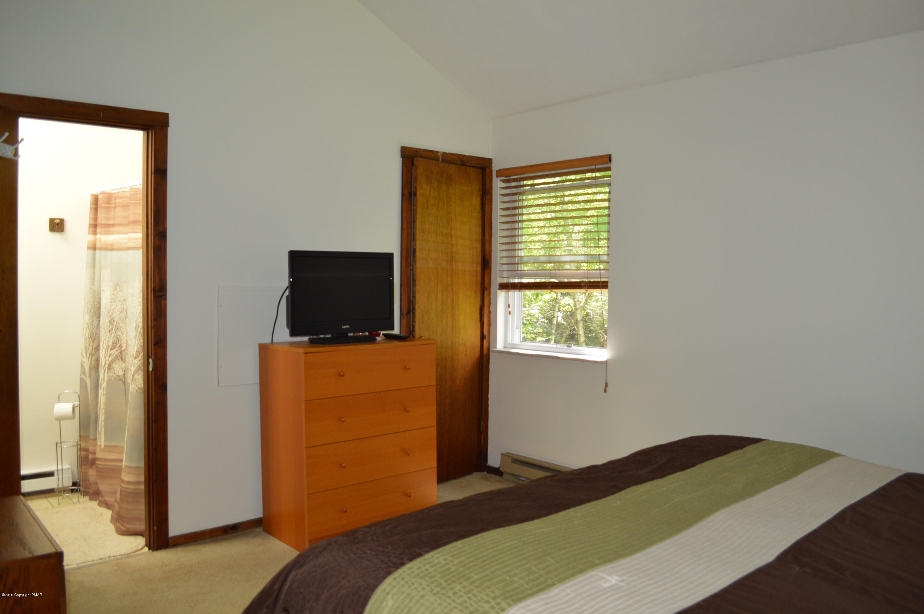 256 Fern Ridge Road Blakeslee, PA 18610 - Photo 14 of 27 a bedroom with a bed and flat screen tv