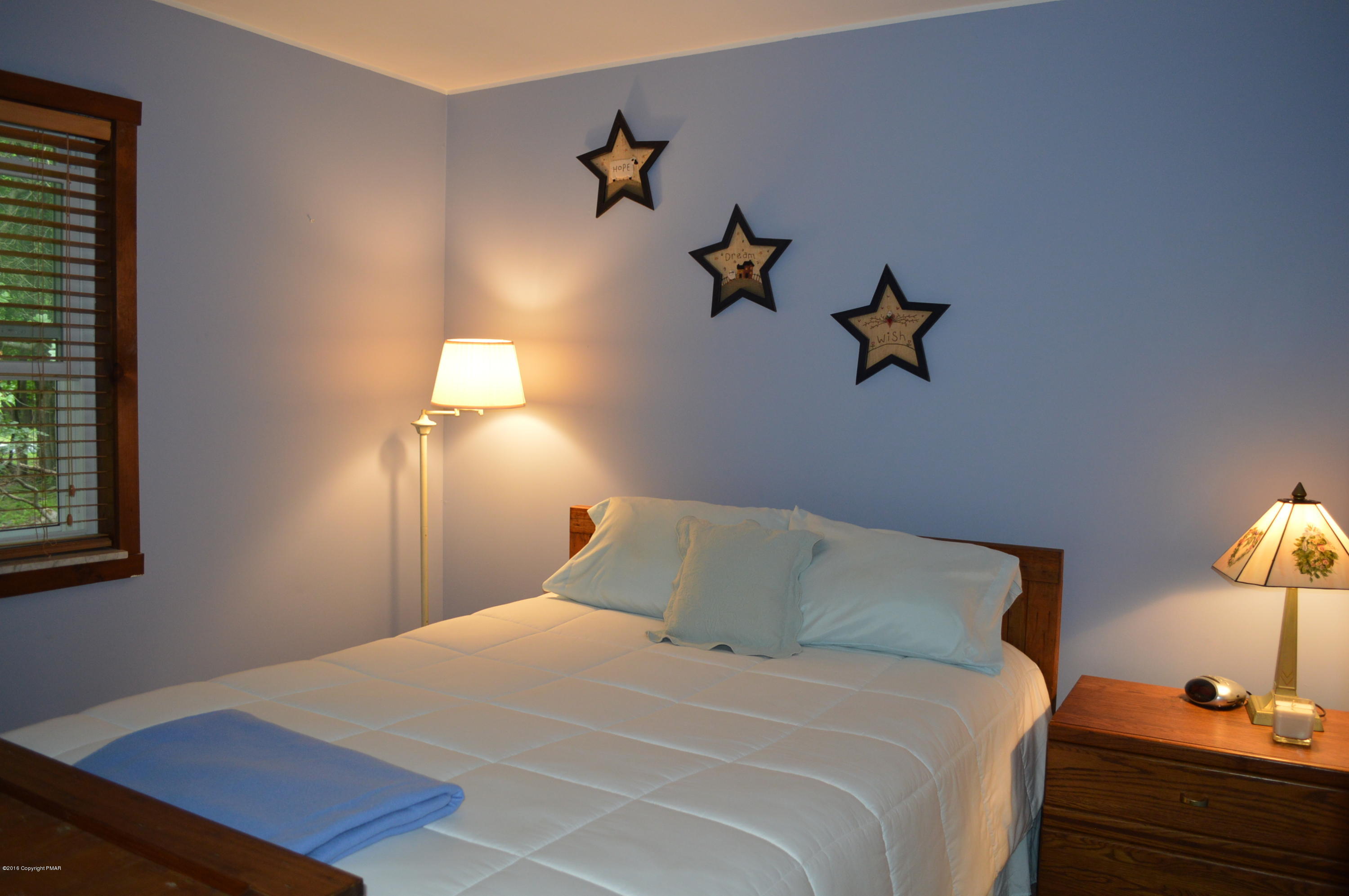 256 Fern Ridge Road Blakeslee, PA 18610 - Photo 17 of 27 a bedroom with a bed and a lamp