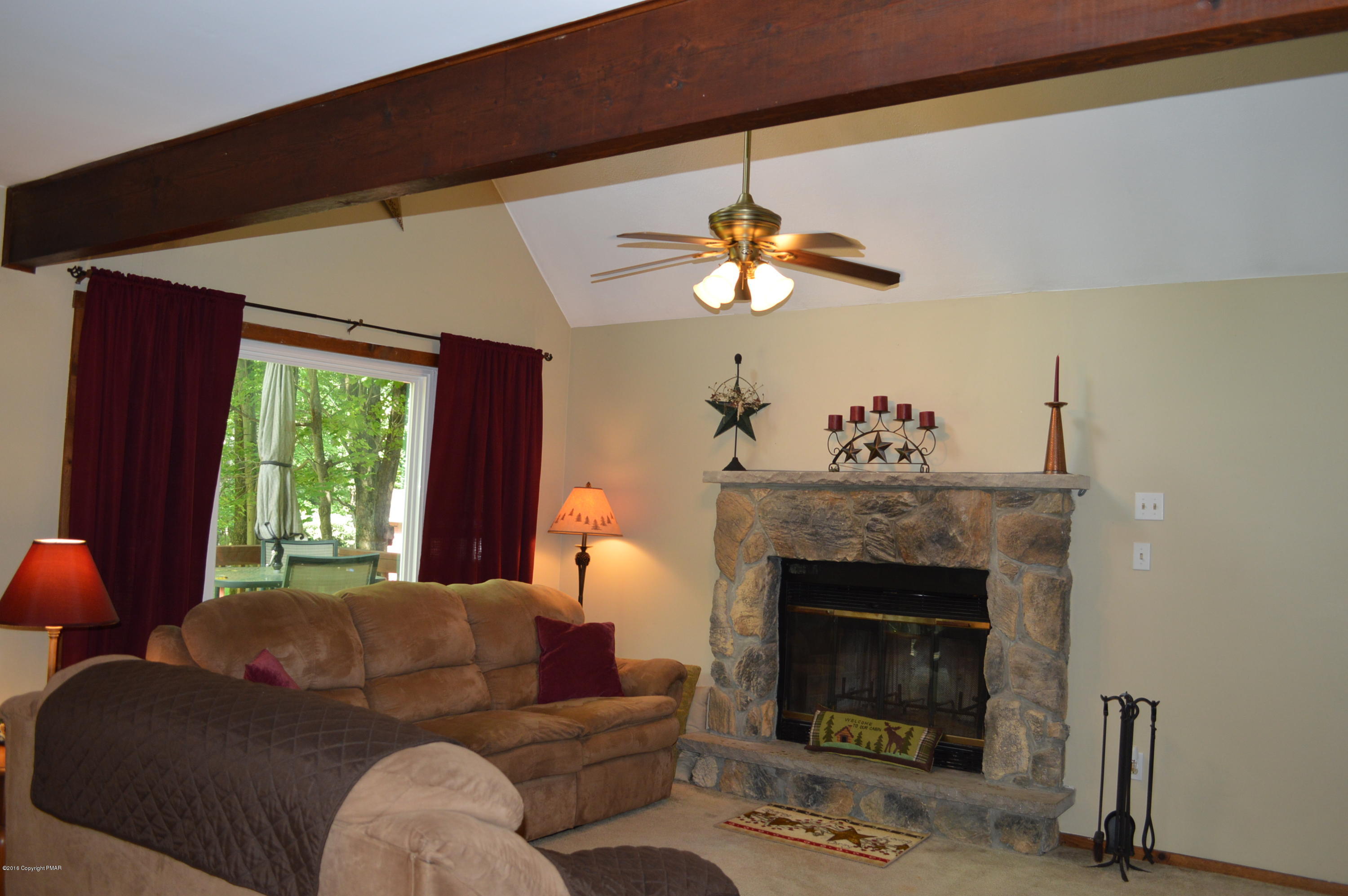 256 Fern Ridge Road Blakeslee, PA 18610 - Photo 6 of 27 a living room with furniture a fireplace and a large window