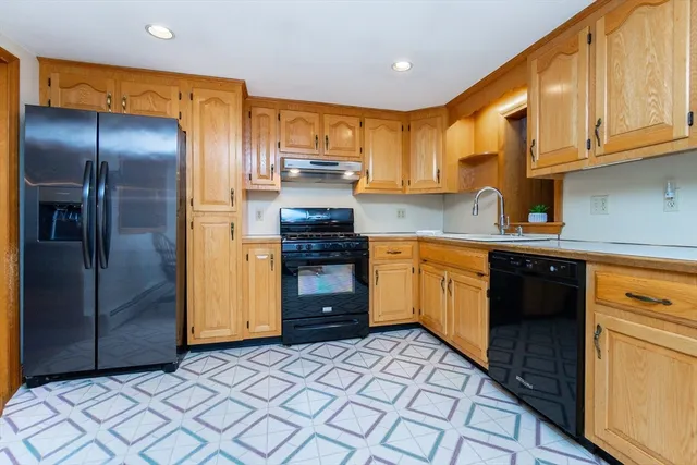 a kitchen with stainless steel appliances granite countertop a stove a sink and a refrigerator