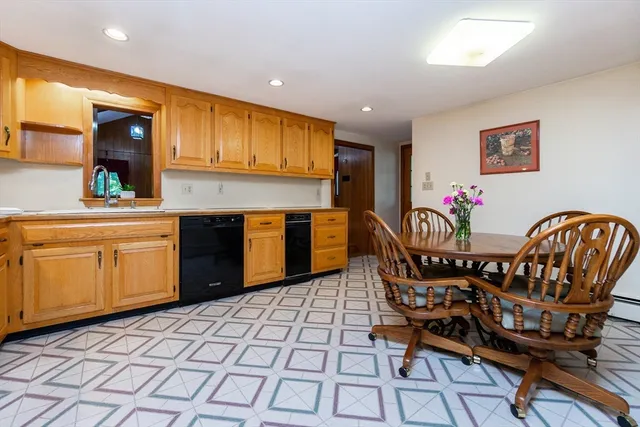 a kitchen with stainless steel appliances granite countertop a sink table and chairs