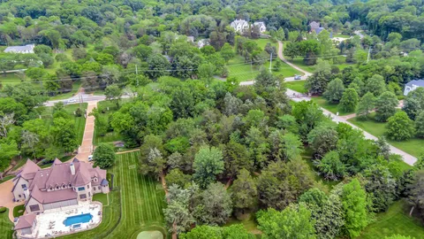 an aerial view of residential houses with outdoor space and trees
