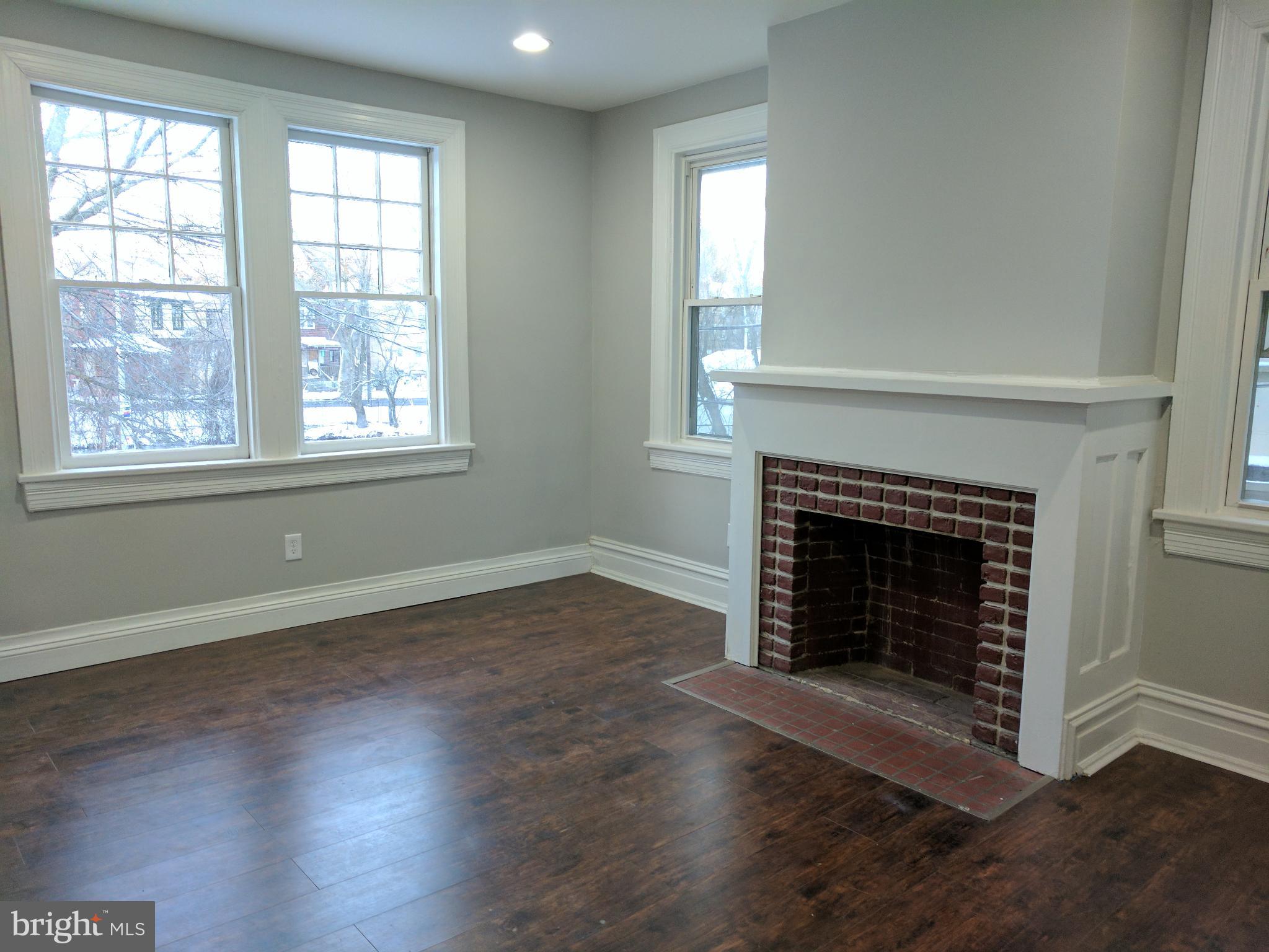 399 West State Street Trenton, NJ 08618 - Photo 17 of 28 an empty room with wooden floor fireplace and windows