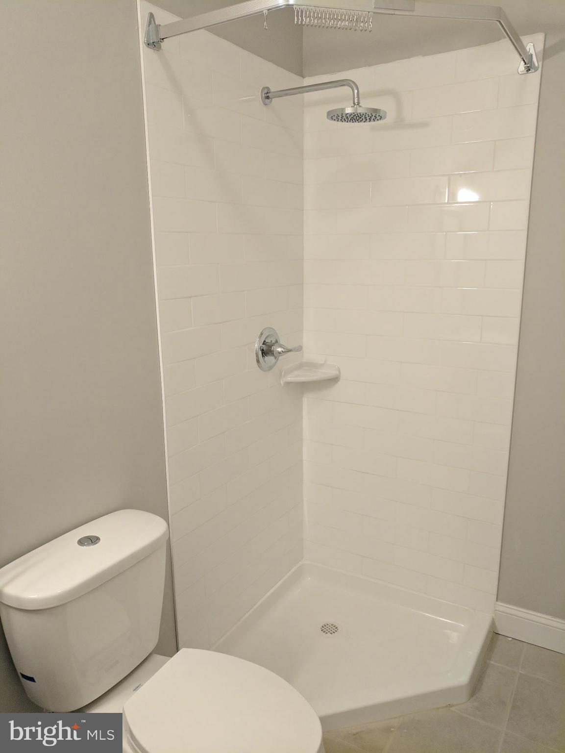 399 West State Street Trenton, NJ 08618 - Photo 19 of 28 a white toilet sitting next to a bath tub