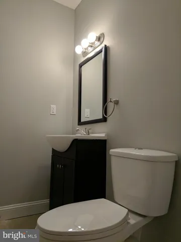 a bathroom with a toilet a sink and mirror