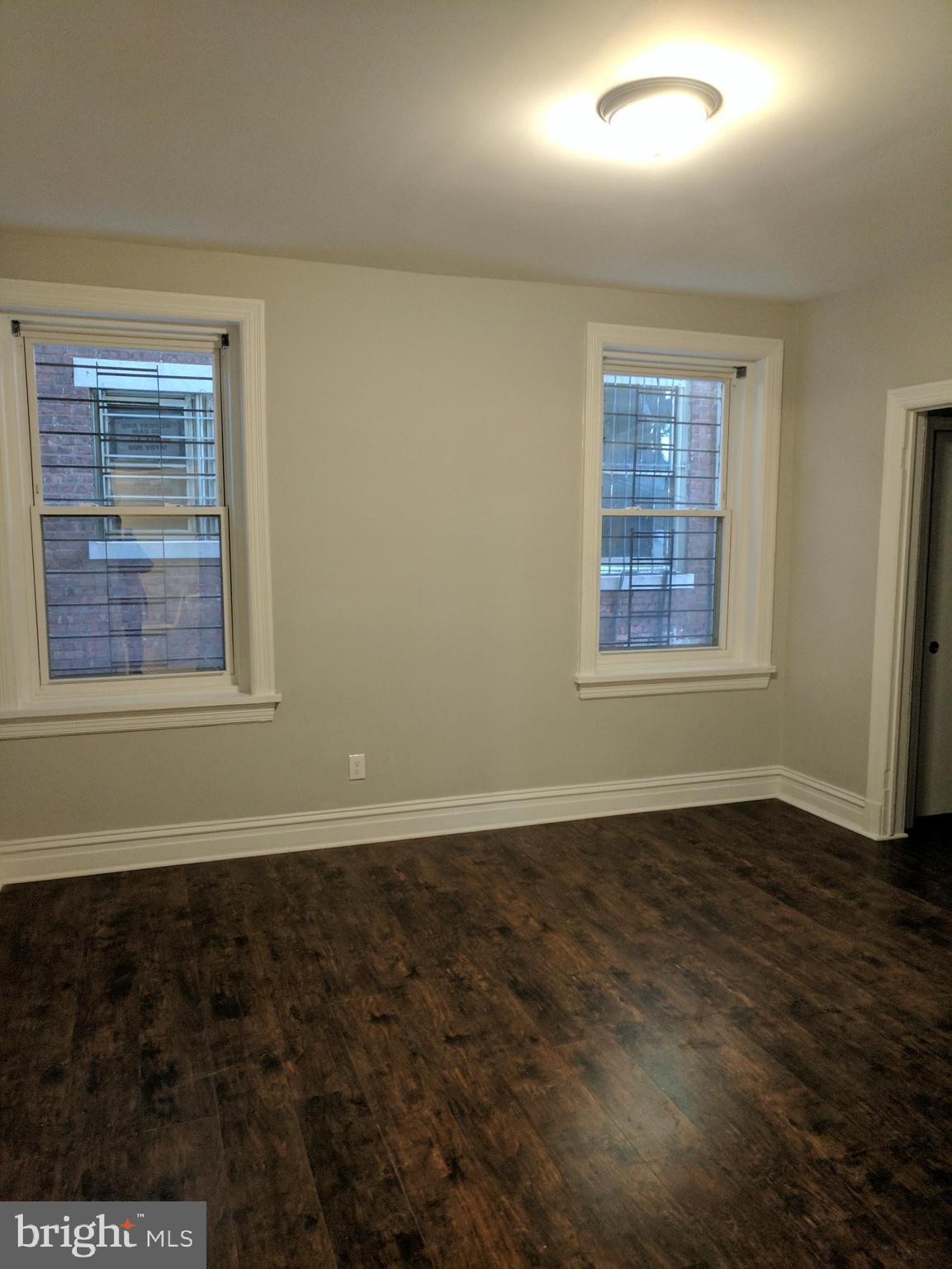 399 West State Street Trenton, NJ 08618 - Photo 2 of 28 an empty room with wooden floor and windows