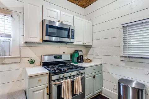 a kitchen with stainless steel appliances white cabinets and a stove top oven