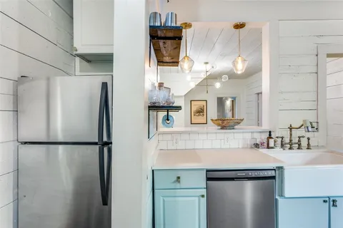 a kitchen with stainless steel appliances granite countertop a refrigerator a sink and a refrigerator