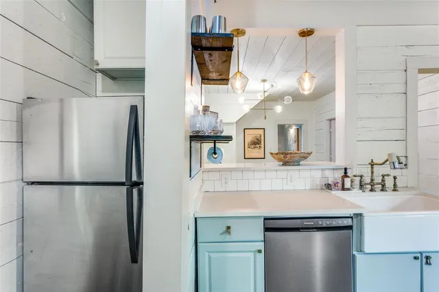 a kitchen with stainless steel appliances granite countertop a refrigerator a sink and a refrigerator