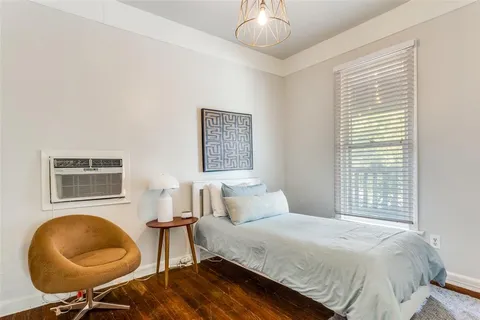 a bedroom with a bed cabinets and a window