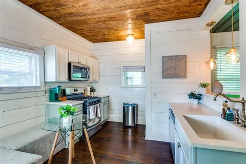 a kitchen that has a table chairs in it and a microwave