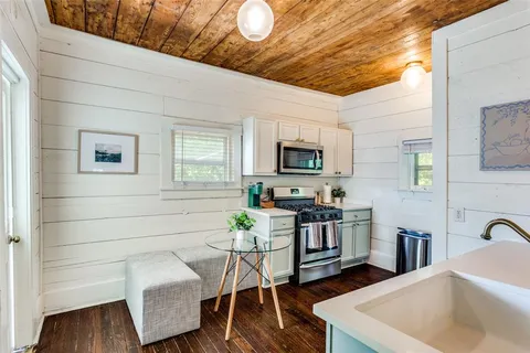 a kitchen with stainless steel appliances kitchen island granite countertop a sink a stove cabinets counter space and wooden floor