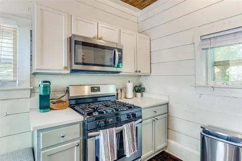 a kitchen with granite countertop a stove sink and cabinets