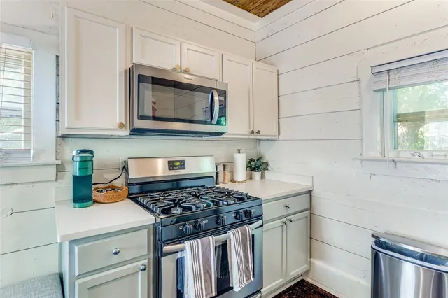 a kitchen with granite countertop a stove sink and cabinets