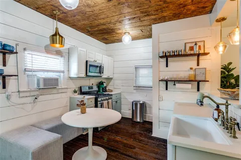 a kitchen with stainless steel appliances a sink a stove a table and chairs