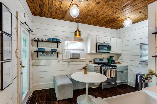 a kitchen with stainless steel appliances a sink a microwave cabinets and wooden floor