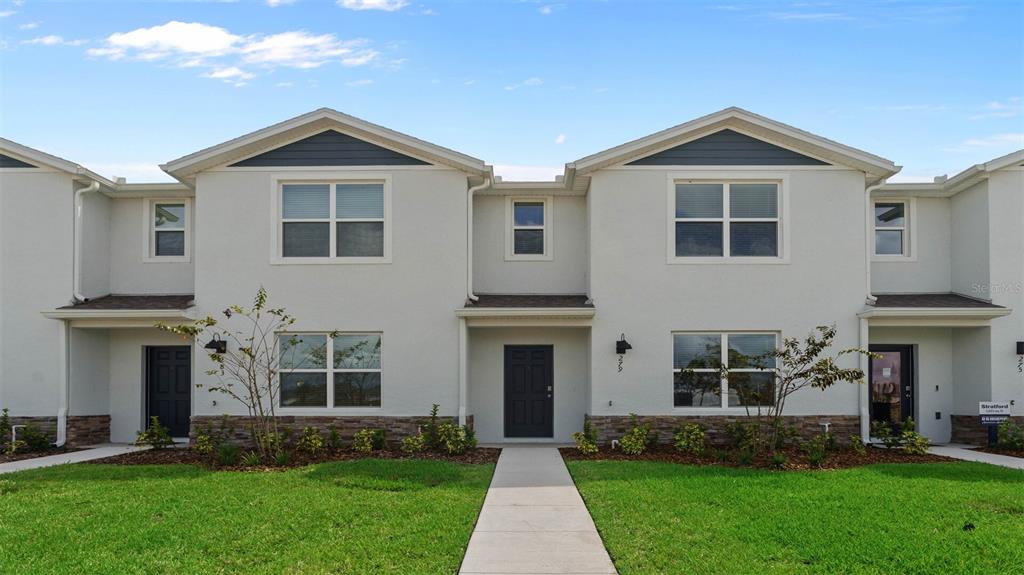 5674 Anders Way St. Cloud, FL 34771 - Photo 1 of 1 a front view of a house with a yard and plants