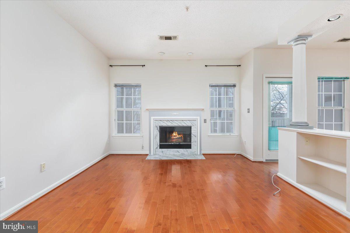 1705 Lake Shore Crest Drive, Unit 25 Reston, VA 20190 - Photo 6 of 31 a view of an empty room with wooden floor fireplace and a window