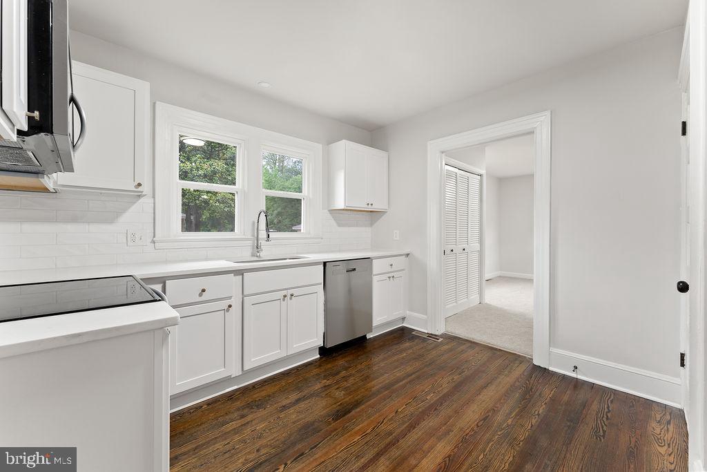 10221 Dahlgren Road King George, VA 22485 - Photo 8 of 31 a kitchen with white cabinets and wooden floor
