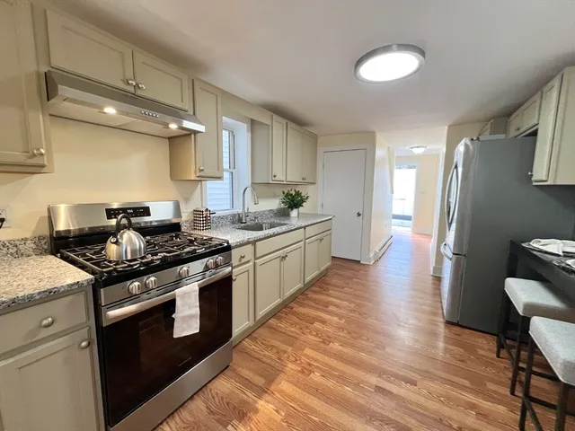 a kitchen with stainless steel appliances a stove a sink and a refrigerator