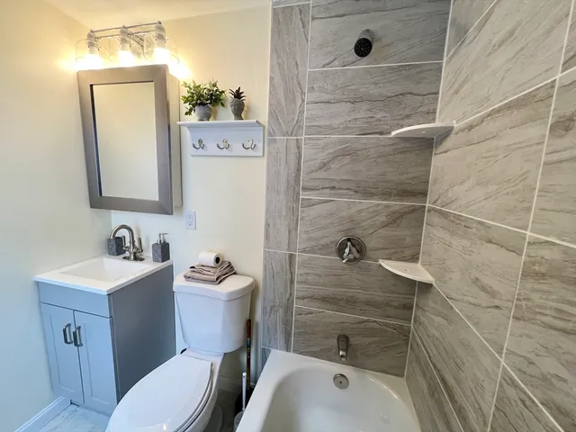 a bathroom with a sink a toilet and shower