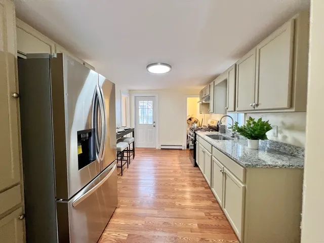 a kitchen with stainless steel appliances granite countertop a refrigerator a stove and a wooden cabinets