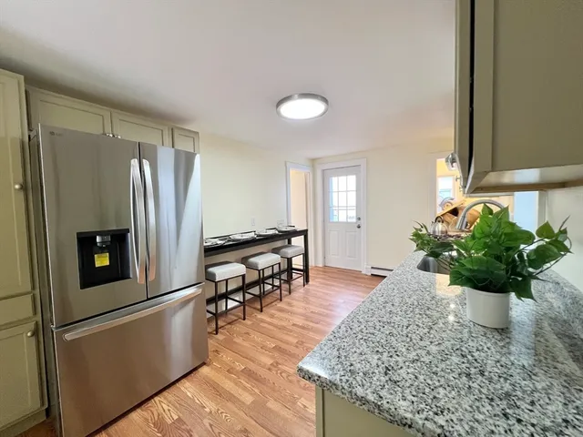 a kitchen with stainless steel appliances granite countertop sink table and chairs