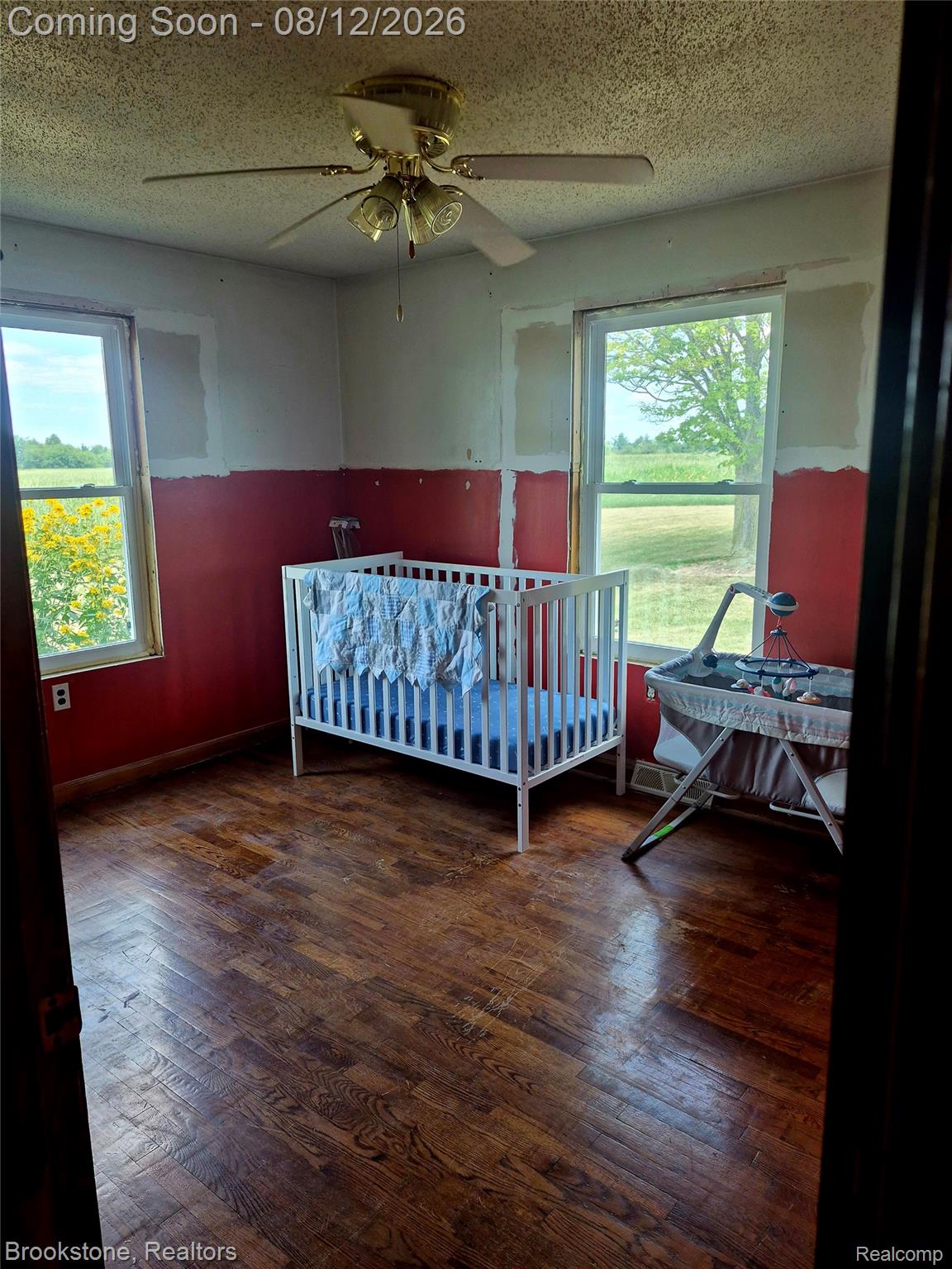 8426 Lake Pleasant Road Clifford, MI 48727 - Photo 16 of 33 Room featuring wood-finish flooring, two windows, and a ceiling fan with integrated lighting