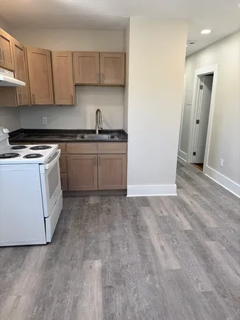 a kitchen with granite countertop a sink and a stove top oven