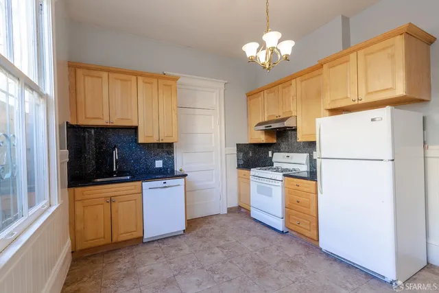 a kitchen with cabinets a refrigerator and a stove