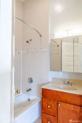 a bathroom with a tub sink and mirror