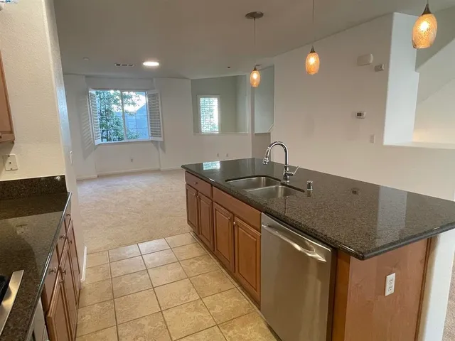 a kitchen with granite countertop a sink and a stove