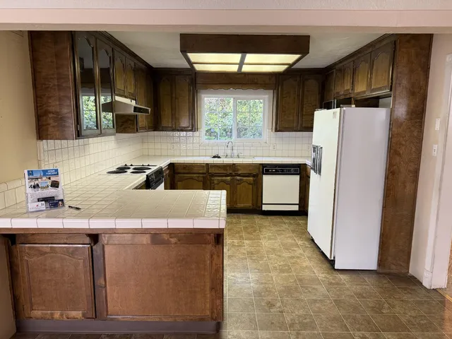 a kitchen with a refrigerator sink and cabinets
