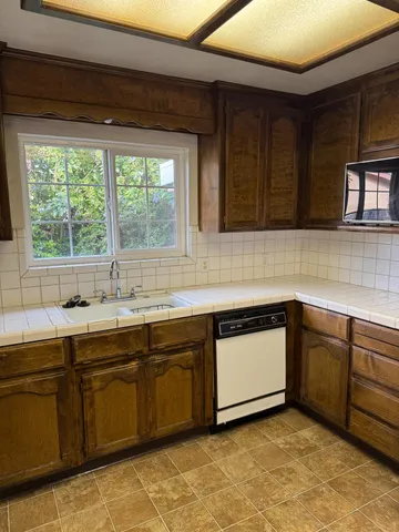 a kitchen with stainless steel appliances kitchen island wooden cabinets and granite counter tops
